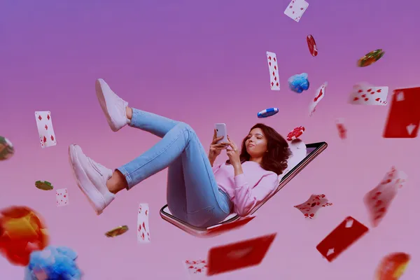 A young woman relaxing with her phone while dynamic casino elements float around her, illustrating the smooth mobile experience offered by the CROWNDB app.