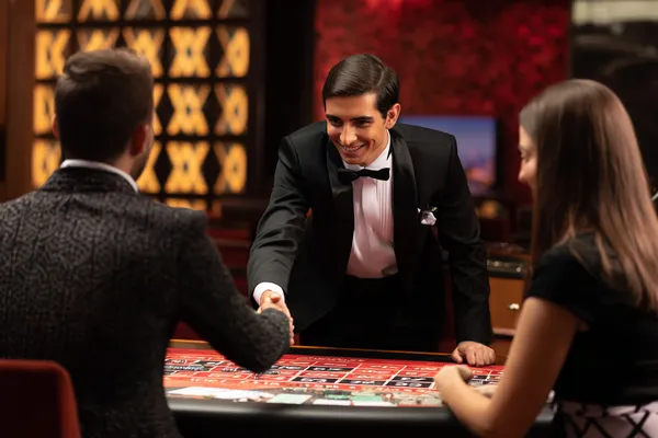 A woman in a luxurious green gown next to an ornate roulette wheel, capturing the upscale casino mood of CROWNDB.